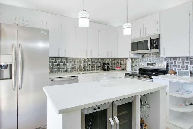 kitchen with appliances with stainless steel finishes, decorative light fixtures, white cabinetry, sink, and wine cooler