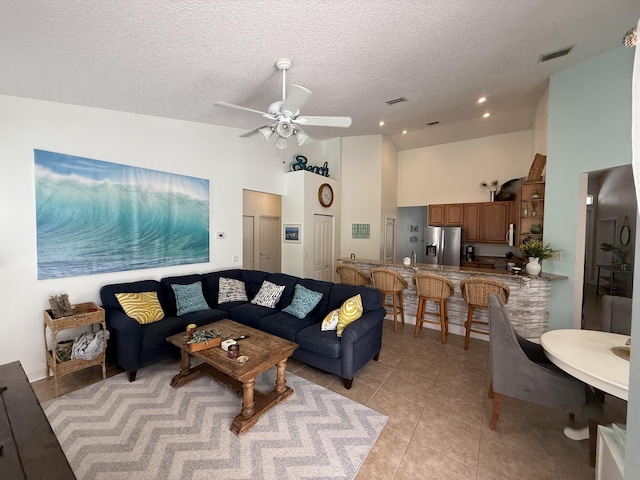 living room featuring light tile patterned flooring, high vaulted ceiling, a textured ceiling, and ceiling fan