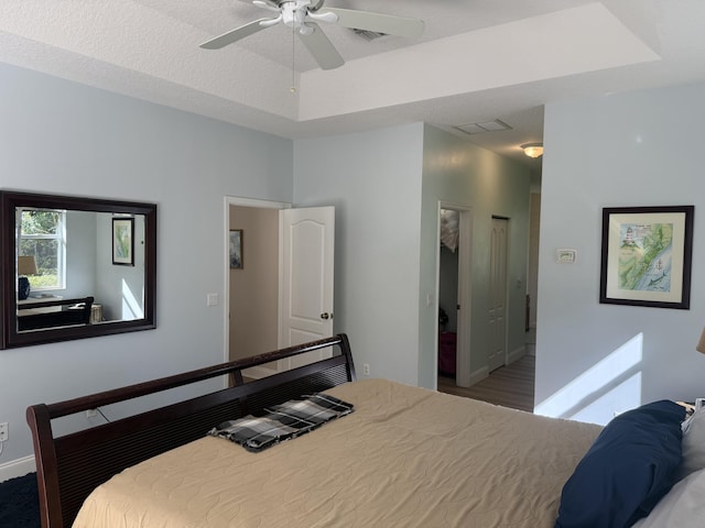 bedroom with a tray ceiling and ceiling fan