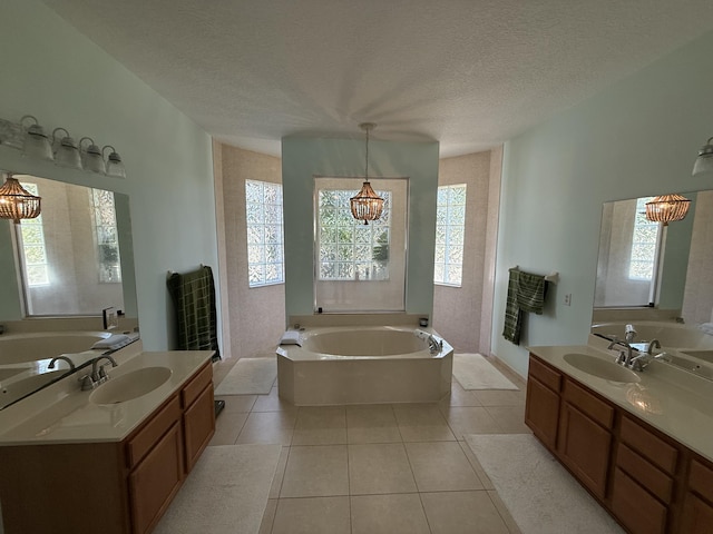 bathroom featuring vanity, a textured ceiling, tile patterned floors, and a bathing tub