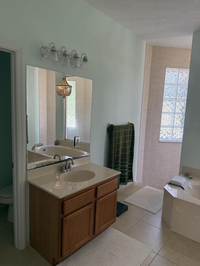 bathroom with tile patterned floors, toilet, a textured ceiling, vanity, and a washtub