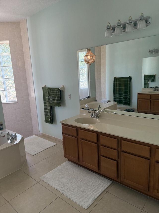 bathroom featuring vanity, a bath, tile patterned floors, and a textured ceiling