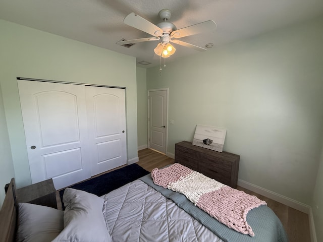 bedroom featuring ceiling fan, dark hardwood / wood-style flooring, and a closet