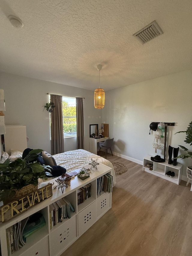 bedroom with wood-type flooring and a textured ceiling