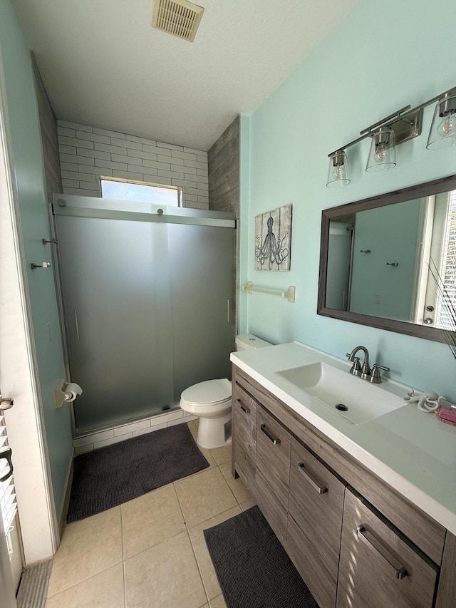 bathroom with tile patterned floors, toilet, an enclosed shower, and vanity