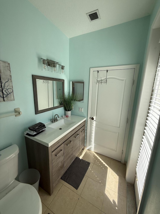 bathroom featuring tile patterned flooring, vanity, and toilet