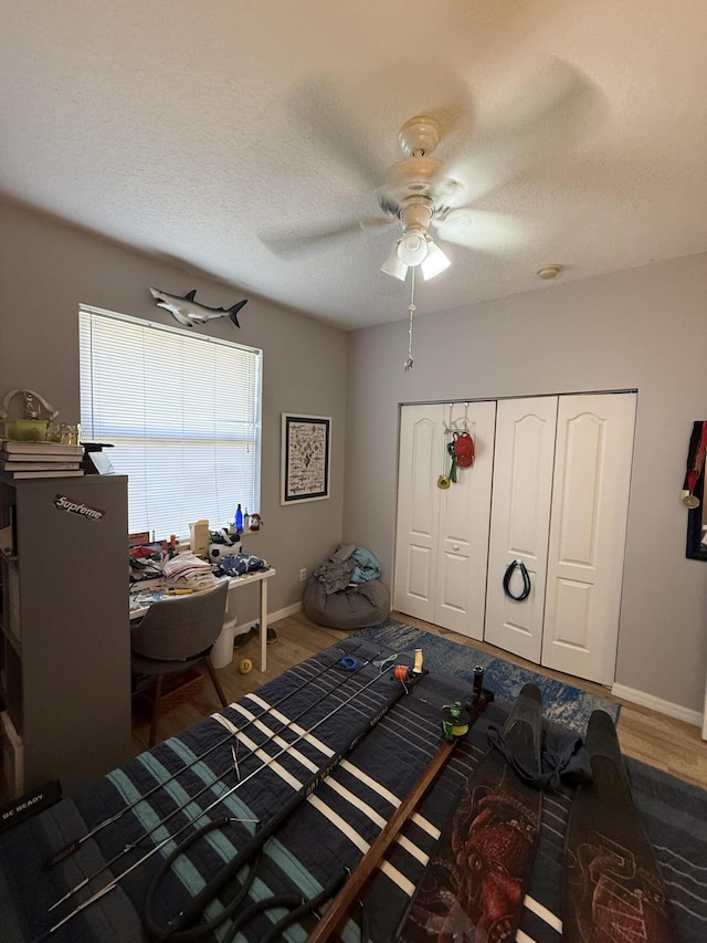 bedroom featuring ceiling fan, dark hardwood / wood-style floors, a closet, and a textured ceiling