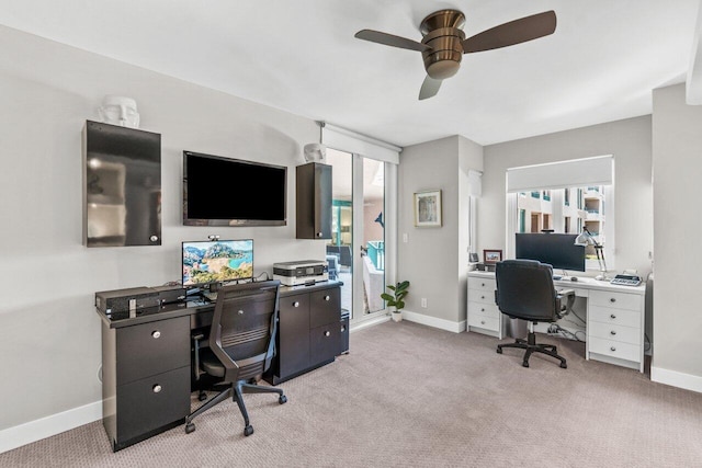 office featuring a healthy amount of sunlight, light carpet, and ceiling fan