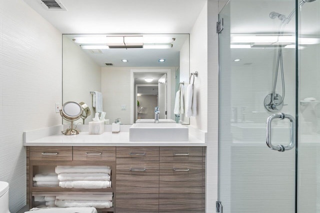 bathroom featuring vanity, an enclosed shower, and toilet