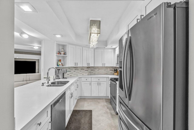 kitchen featuring sink, appliances with stainless steel finishes, backsplash, white cabinets, and light tile patterned flooring