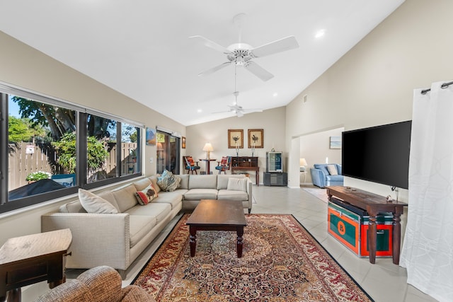 living room featuring ceiling fan, vaulted ceiling, and light tile patterned floors