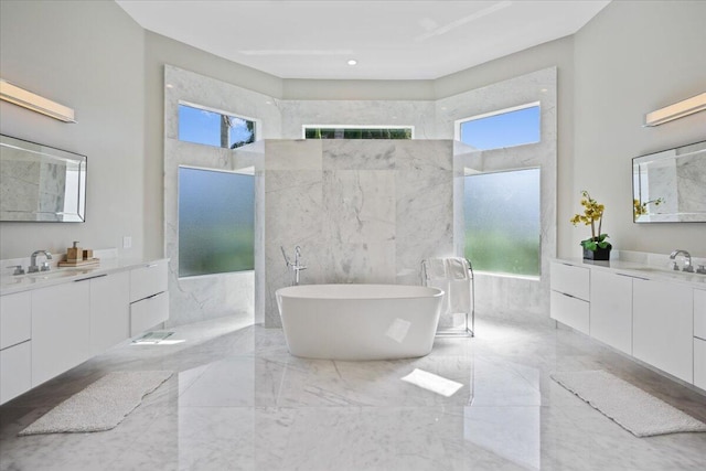 bathroom with vanity, a bath, a towering ceiling, and plenty of natural light