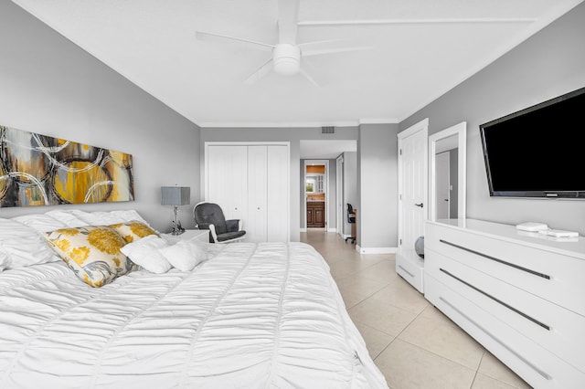 tiled bedroom with ornamental molding, ceiling fan, and a closet