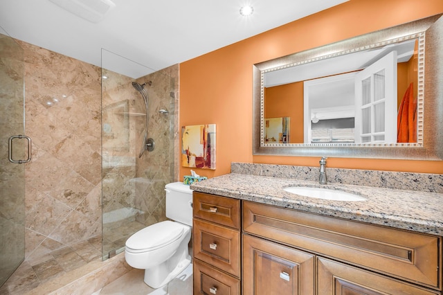 bathroom featuring vanity, toilet, and a shower with shower door