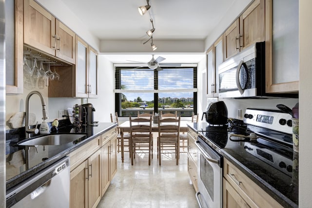 kitchen featuring appliances with stainless steel finishes, sink, dark stone countertops, ceiling fan, and light brown cabinets