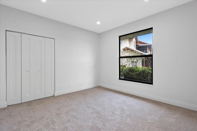 unfurnished bedroom featuring a closet and light carpet