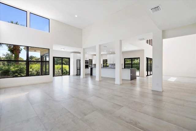 unfurnished living room with a towering ceiling