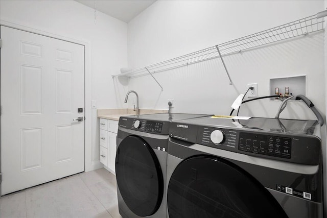 washroom featuring cabinets, washing machine and dryer, and sink