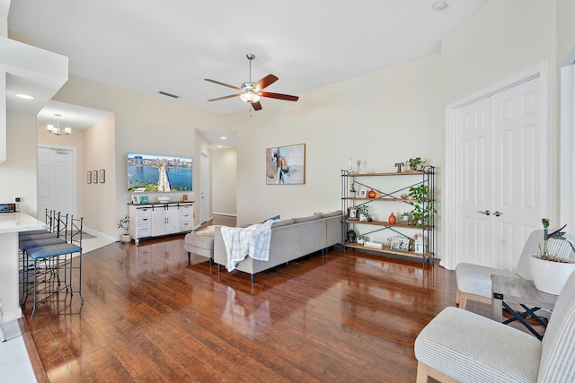 living room featuring dark hardwood / wood-style floors and ceiling fan with notable chandelier