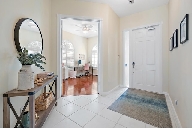 entryway featuring light tile patterned floors and ceiling fan