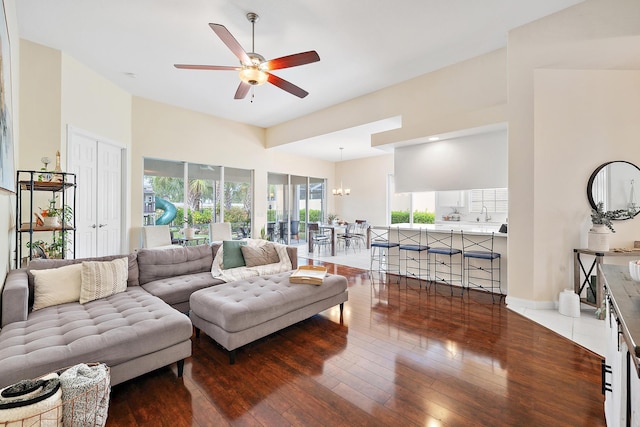 living room featuring ceiling fan with notable chandelier and wood-type flooring