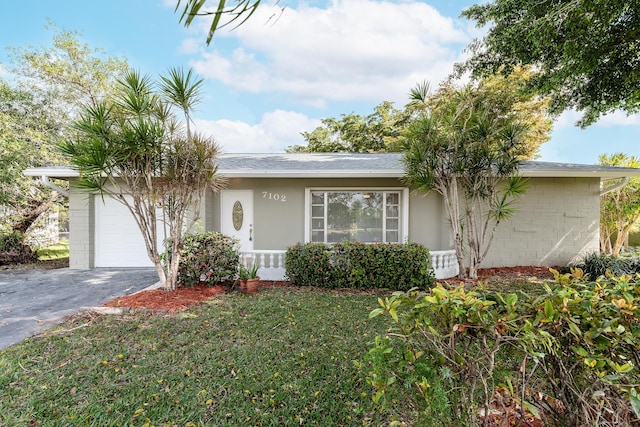 single story home featuring a garage and a front lawn