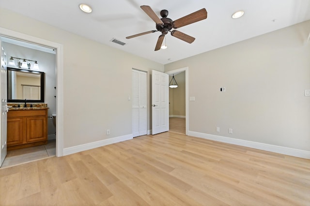 unfurnished bedroom featuring ensuite bathroom, recessed lighting, visible vents, baseboards, and light wood-type flooring