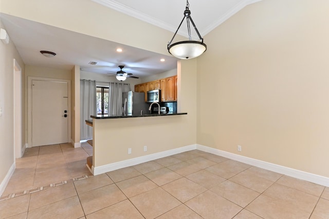 kitchen with light tile patterned floors, dark countertops, appliances with stainless steel finishes, decorative light fixtures, and a peninsula