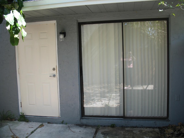 entrance to property with stucco siding