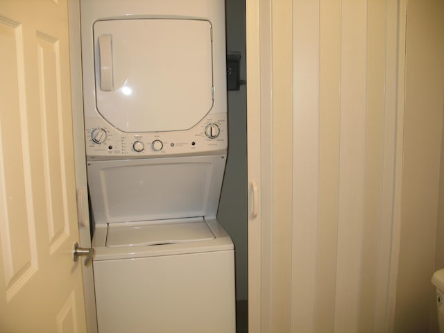 laundry area featuring stacked washer / dryer and laundry area