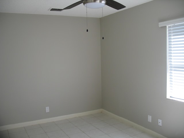 unfurnished room with plenty of natural light, visible vents, ceiling fan, and baseboards