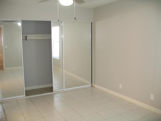 unfurnished bedroom featuring a ceiling fan, light tile patterned flooring, and baseboards