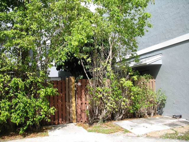 view of side of home featuring fence and stucco siding