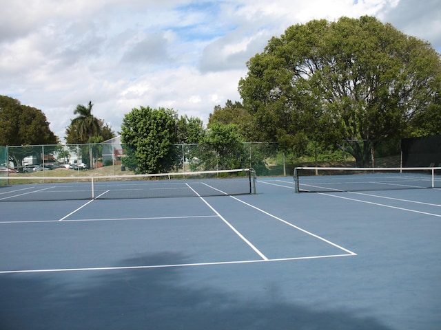 view of tennis court featuring fence