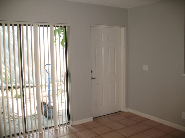 tiled foyer entrance with baseboards