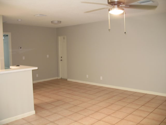 unfurnished room featuring ceiling fan and baseboards