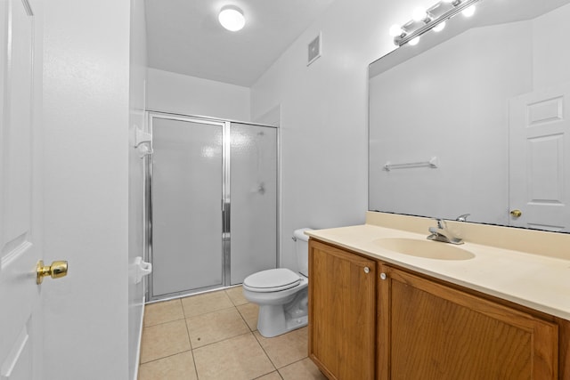 bathroom featuring vanity, toilet, tile patterned floors, and a shower with shower door