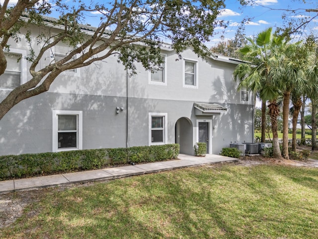 mediterranean / spanish house with a front yard and central air condition unit