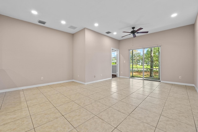 tiled spare room with ceiling fan