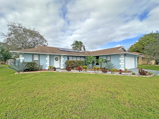 ranch-style house with a garage, a front yard, and solar panels