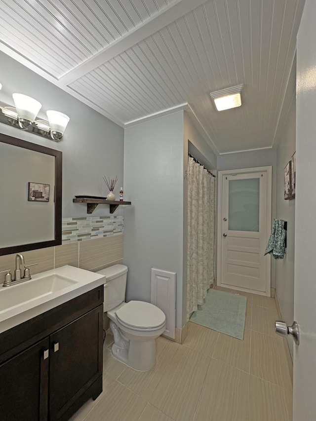 bathroom featuring tile walls, vanity, and toilet