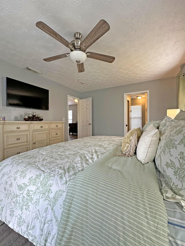 bedroom with a textured ceiling and ceiling fan