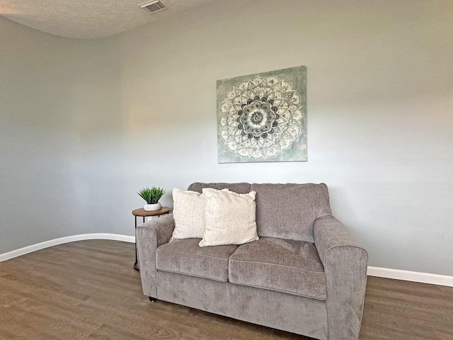 living area featuring dark hardwood / wood-style floors and a textured ceiling