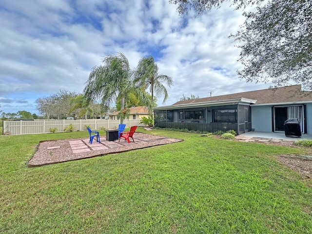 view of yard featuring a fire pit, a sunroom, and a patio