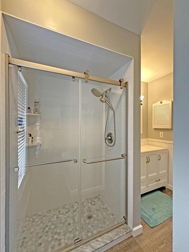 bathroom featuring vanity, wood-type flooring, and a shower with door