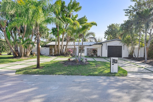 single story home featuring a garage and a front yard