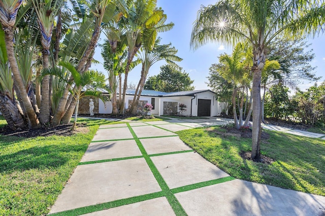 view of front of property with a garage and a front lawn