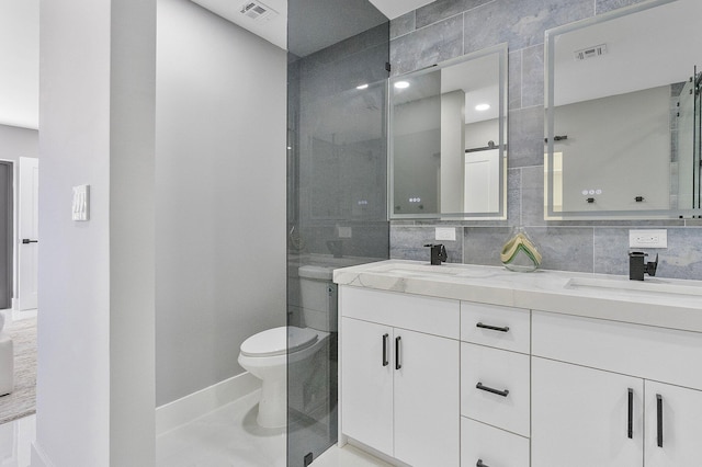 bathroom featuring tile patterned flooring, vanity, tasteful backsplash, toilet, and walk in shower