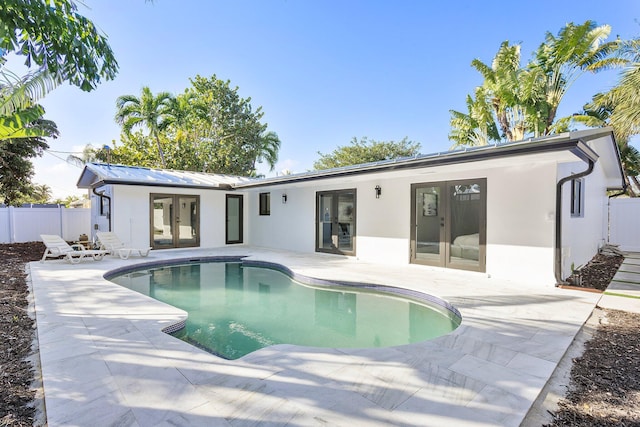 back of property featuring a patio, french doors, and a fenced in pool