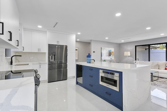 kitchen with light stone countertops, a center island, white cabinets, and stainless steel fridge with ice dispenser